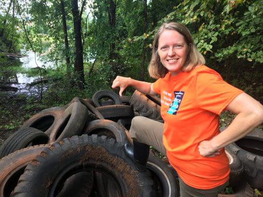 River Steward Kathy Urffer poses with a heap of tires cleaned out the river - no thanks!
