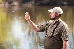 Water Quality Program Manager Ryan O'Donnell collects a water sample